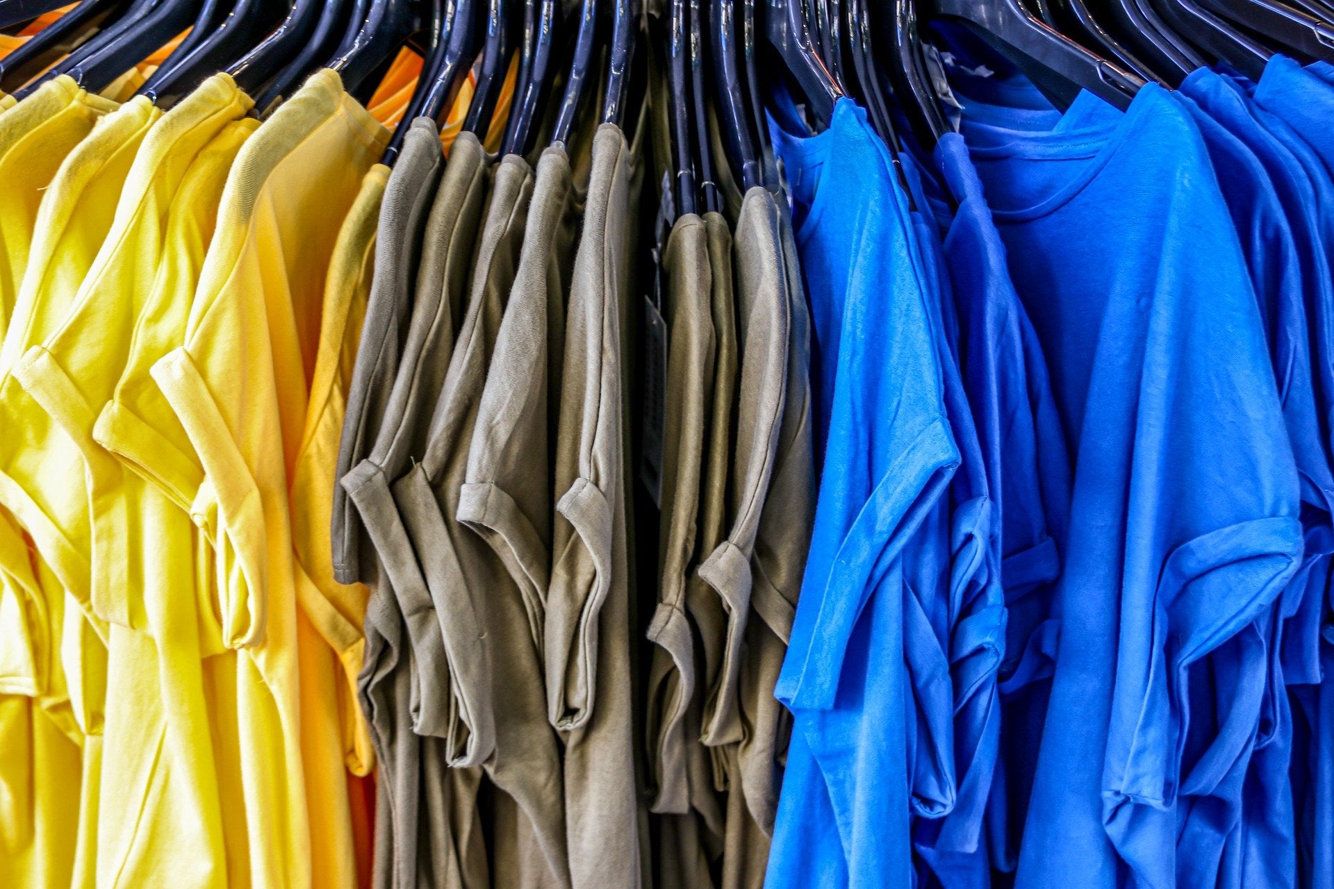 Various colored T-shirts on hangers